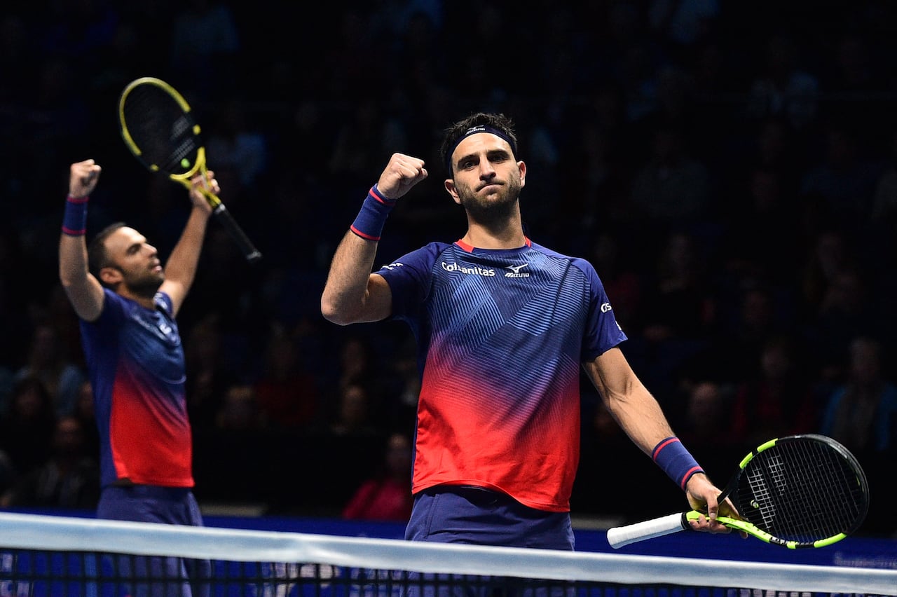 Los colombianos Juan Sebastián Cabal (izq.) y Robert Farah (der.) celebran su victoria sobre los alemanes Kevin Krawietz y Andreas Mies durante su partido de dobles masculino de la ronda preliminar, en el sexto día de las Finales ATP World Tour, disputado en el O2 Arena de Londres el 15 de noviembre de 2019. Los colombianos vencieron a los alemanes Kevin Krawietz y Andreas Mies por 7-6 y 6-2. (Foto de Glyn KIRK / AFP)