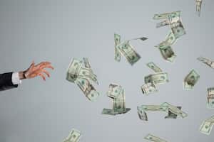 Hand grasping at fluttering money