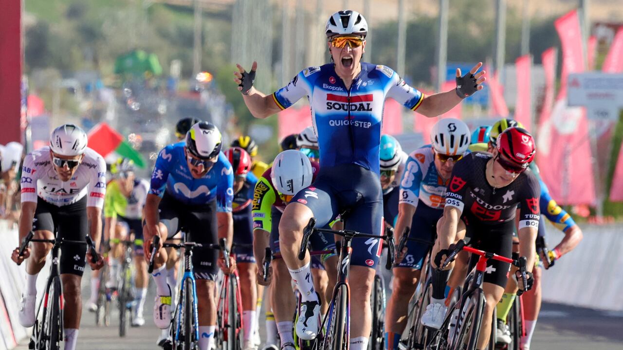 El belga Tim Merlier (C), de Soudal Quick-Step, celebra mientras cruza la línea de meta para ganar la etapa 1 del 6.° Tour de los EAU 2024, desde Al Dhafra Walk hasta Liwa, el 19 de febrero de 2024. (Foto de Giuseppe CACACE / AFP)