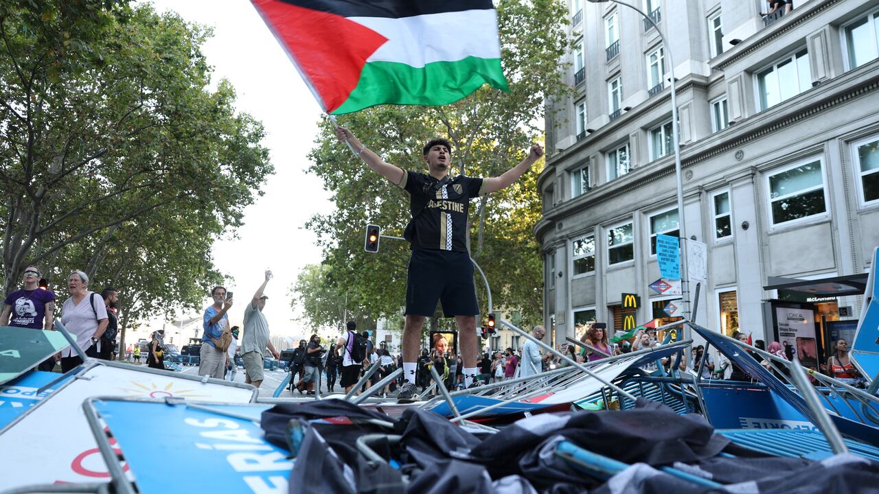 Un manifestante pro-palestino ondea una bandera palestina después de que los manifestantes invadieran la calle durante la 21.ª y última etapa de la Vuelta a España 2025.