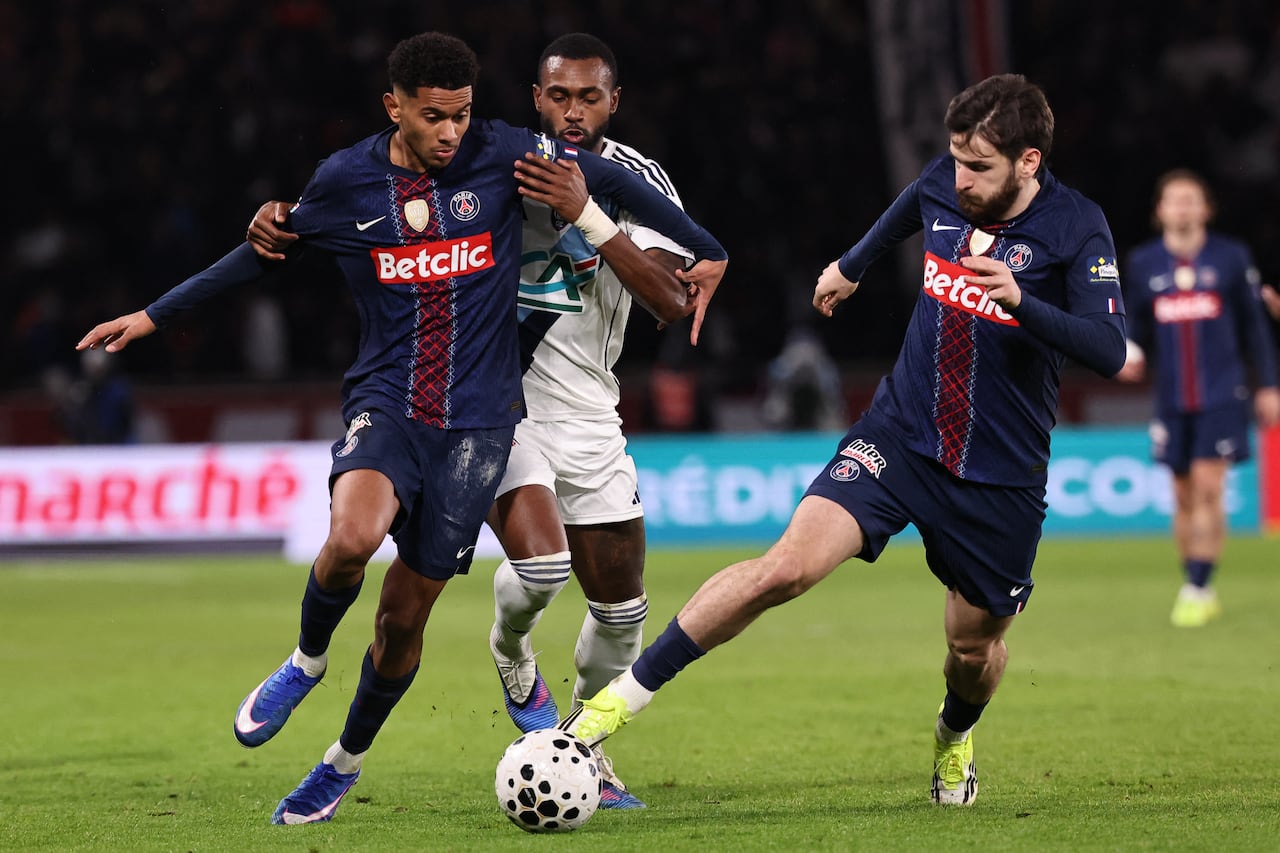 El centrocampista francés del Paris Saint-Germain #02 Warren Zaire-Emery (izq.) y el delantero georgiano del Paris Saint-Germain #07 Khvicha Kvaratskhelia (der.) luchan por el balón con el defensa brasileño del Paris FC #06 Otavio durante el partido de dieciseisavos de final de la Copa de Francia entre el Paris Saint-Germain (PSG) y el Paris FC en el estadio Parc des Princes en París el 12 de enero de 2026. (Foto de Anne-Christine POUJOULAT / AFP)