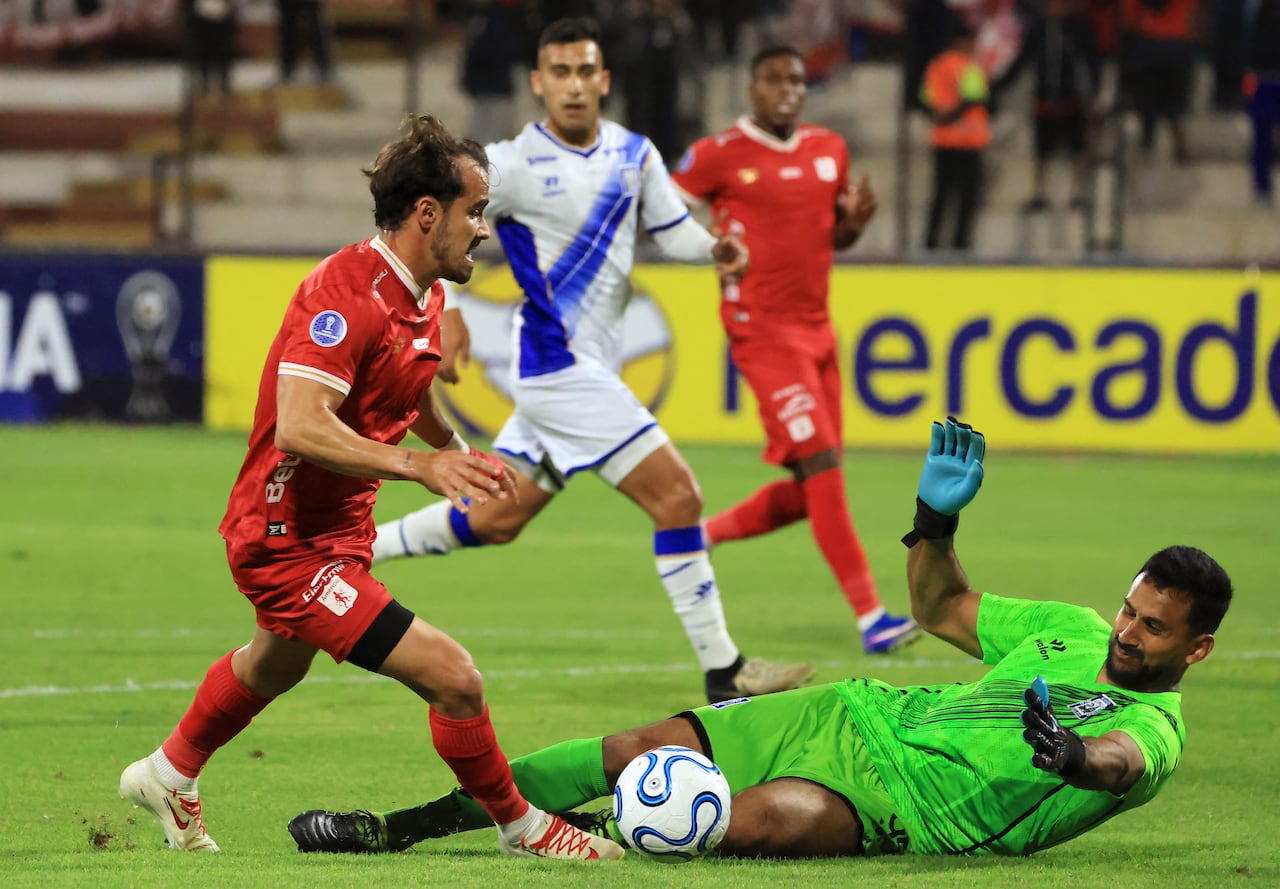 El delantero número 21 del América de Cali, Tomás Ángel (izquierda), y el portero número 95 del Alianza Atlético, Daniel Prieto, luchan por el balón durante el partido de la fase de grupos de la Copa Sudamericana entre el Alianza Atlético de Perú y el América de Cali de Colombia en el estadio Miguel Grau del Callao en Bellavista, región del Callao, Perú, el 6 de mayo de 2026. (Foto de Connie FRANCE / AFP)