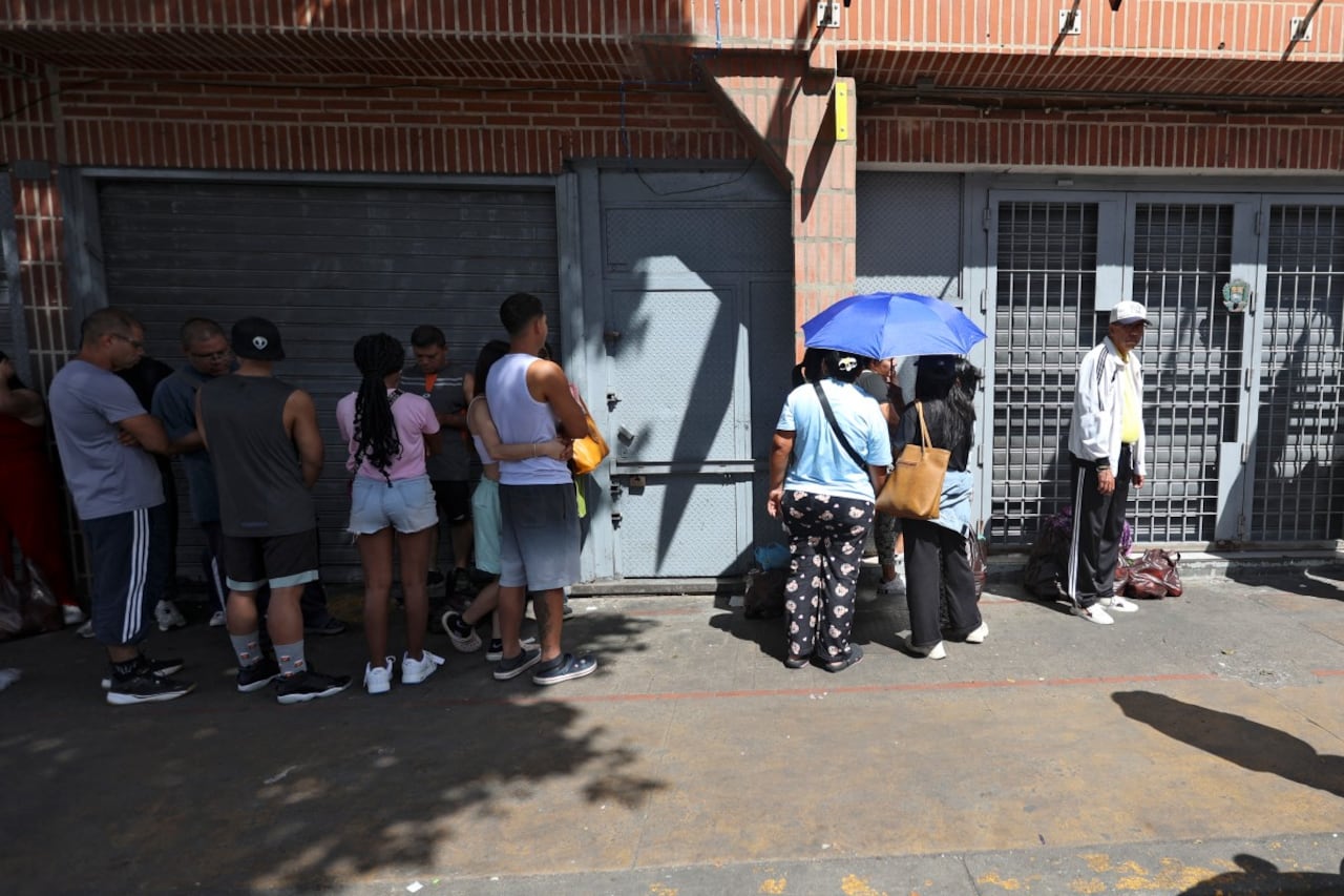 La gente hace fila frente a una panadería en Caracas el 3 de enero de 2026, después de que las fuerzas estadounidenses capturaran al líder venezolano Nicolás Maduro. Algunos también salen a supermercados en busca de víveres.