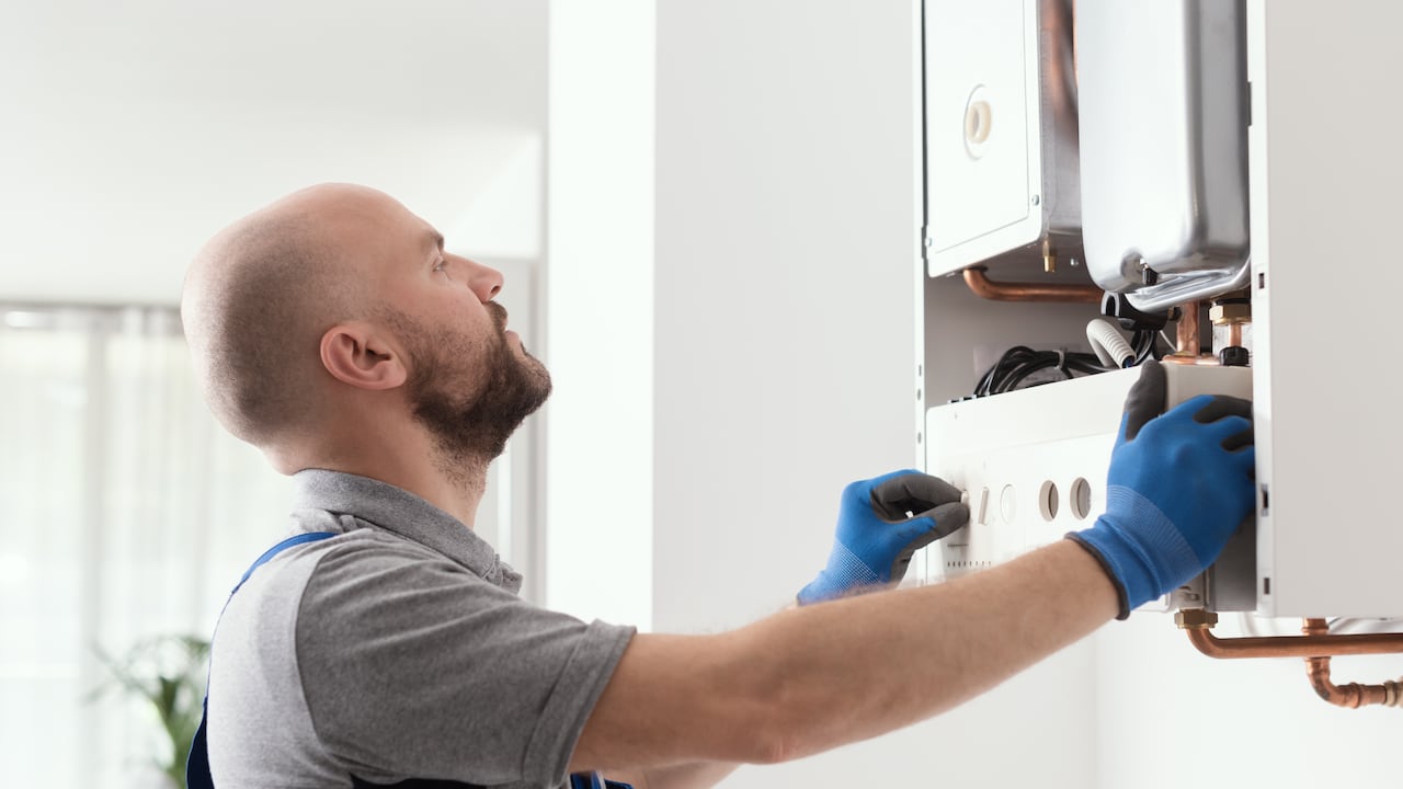 Professional qualified engineer testing a gas boiler after repair