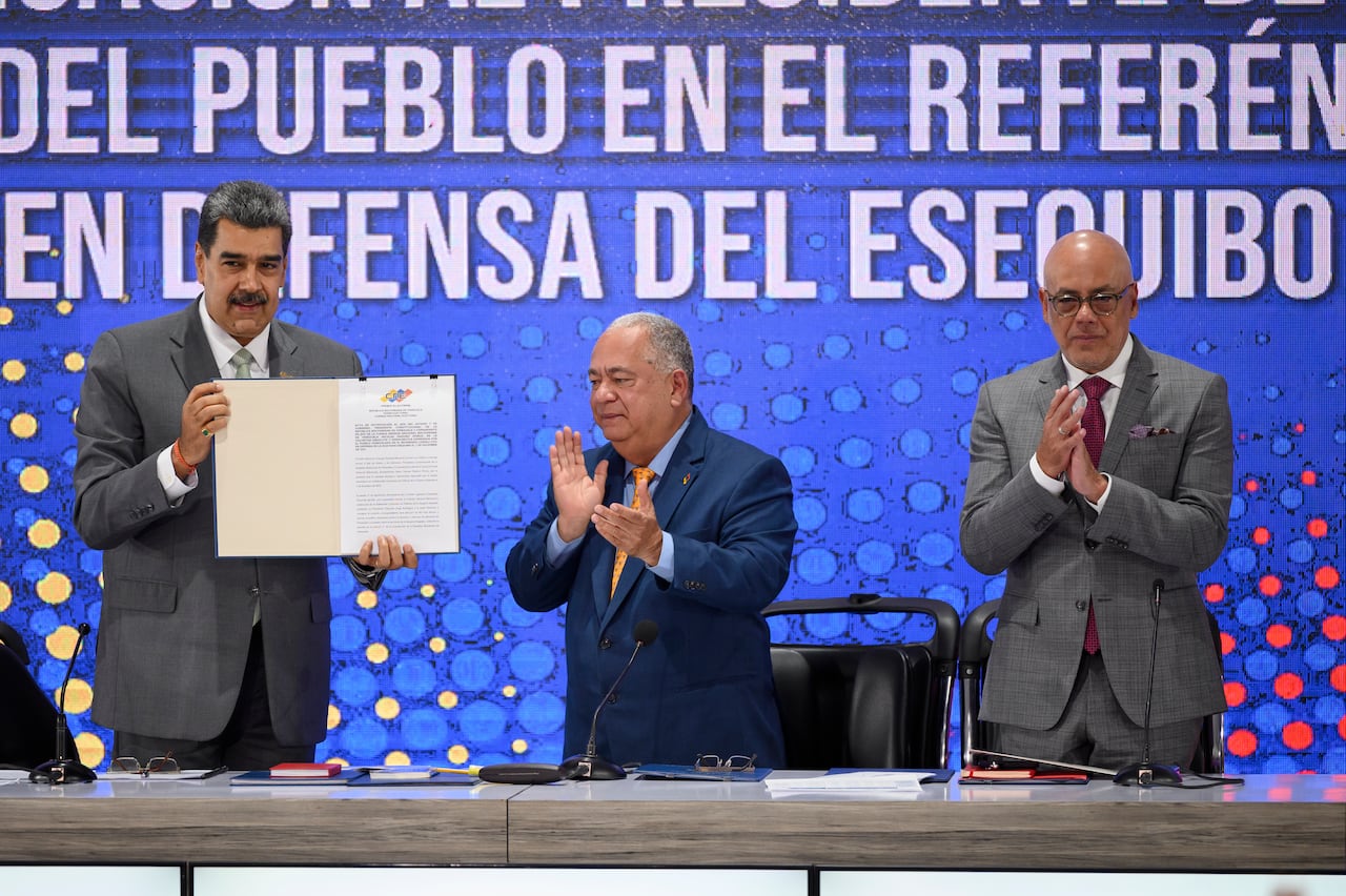 El Presidente de Venezuela, Nicolás Maduro, el Rector del Consejo Nacional Electoral, Elvis Amoroso, y el Presidente de la Asamblea Nacional, Jorge Rodríguez, muestran el acta de notificación del referéndum durante una conferencia de prensa el día después de que los venezolanos votaron en el referéndum sobre el conflicto fronterizo con el país vecino Guyana sobre la potencial región del Esequibo, rica en petróleo, el 4 de diciembre de 2023 en Caracas, Venezuela.