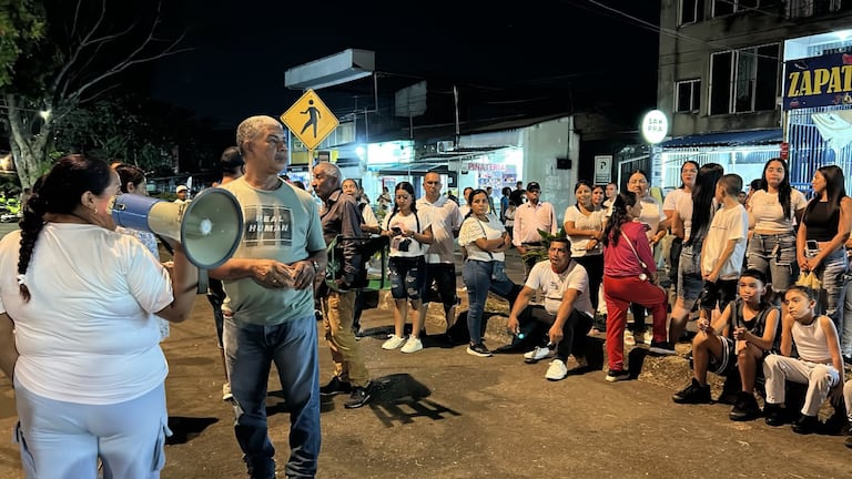 Familiares y vecinos de María Camila Potosí sostienen velas y globos blancos durante la velatón realizada en una cancha del barrio Meléndez, en el sur de Cali, para pedir por el regreso de la bebé Alahia.