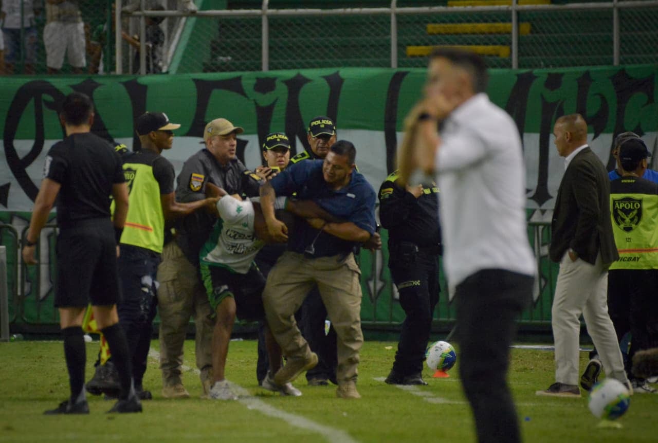 Hincha del Deportivo Cali en detenido por la Policía y fuerza de seguridad del estadio ante de poder agredir al técnico Rafael Dudamel ( primero de derecha a izquierda).