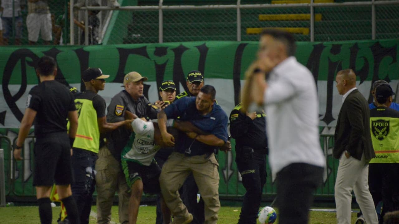 Hincha del Deportivo Cali en detenido por la Policía y fuerza de seguridad del estadio ante de poder agredir al técnico Rafael Dudamel ( primero de derecha a izquierda).