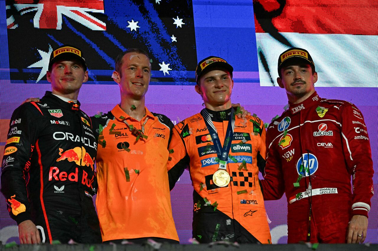 El piloto australiano de McLaren, Oscar Piastri (2D), celebra en el podio junto al piloto holandés Max Verstappen (I), segundo clasificado, de Red Bull Racing, y el piloto monegasco Charles Leclerc (D), tercer clasificado, de Ferrari, durante la ceremonia de trofeos del Gran Premio de Fórmula Uno de Arabia Saudita 2025.