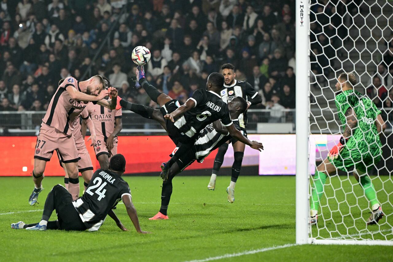 El centrocampista marfileño de Angers #06 Jean-Eudes Aholou y el delantero senegalés de Angers #07 Ibrahima Niane (C) intentan una patada de tijera frente al defensor eslovaco del Paris Saint-Germain #37 Milan Skriniar (L) durante el partido de fútbol francés L1.