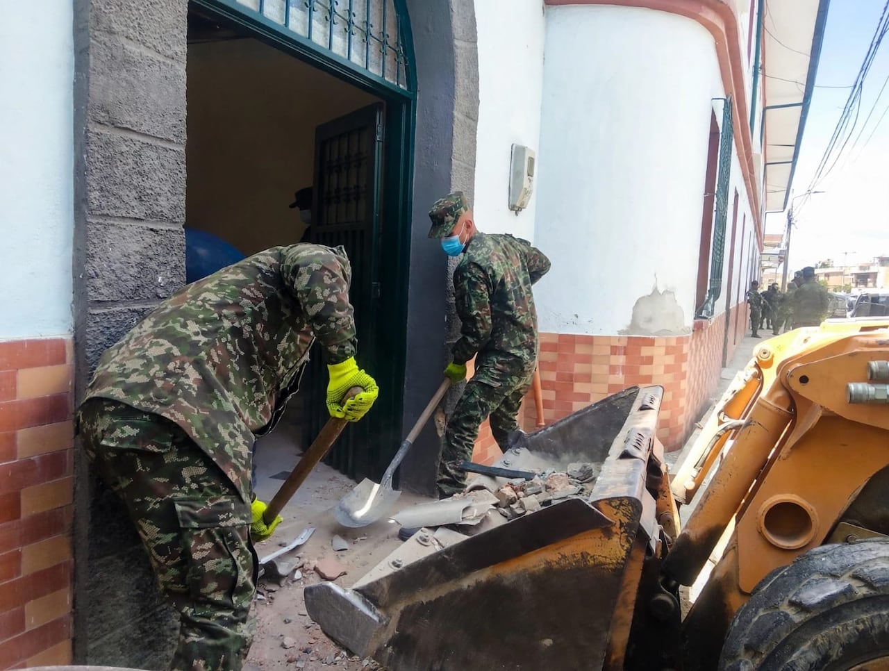 Con picas y palas, los uniformados trabajaron junto a miembros de la comunidad local para despejar el área colapsada dentro de la infraestructura del asilo
