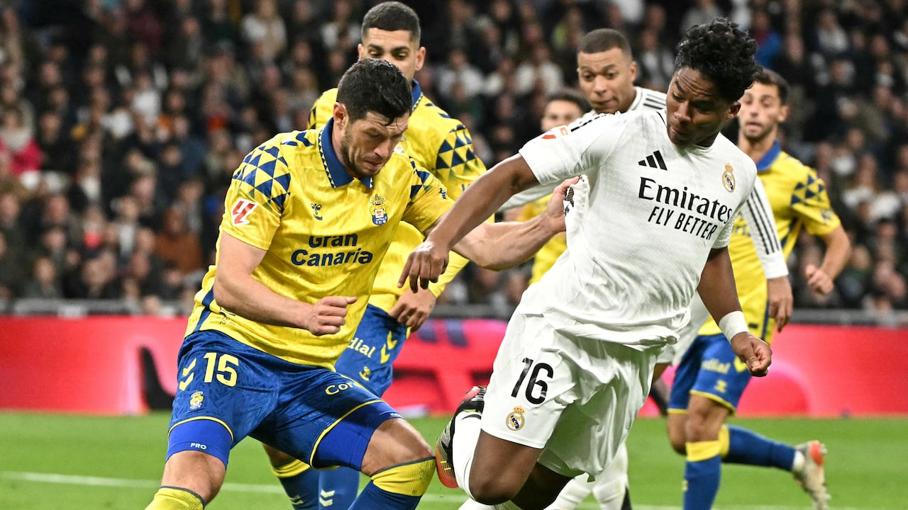 El delantero brasileño del Real Madrid #16 Endrick lucha por el balón con el defensor escocés de Las Palmas #15 Scott McKenna durante la liga española.