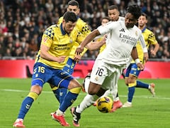 El delantero brasileño del Real Madrid #16 Endrick lucha por el balón con el defensor escocés de Las Palmas #15 Scott McKenna durante la liga española.