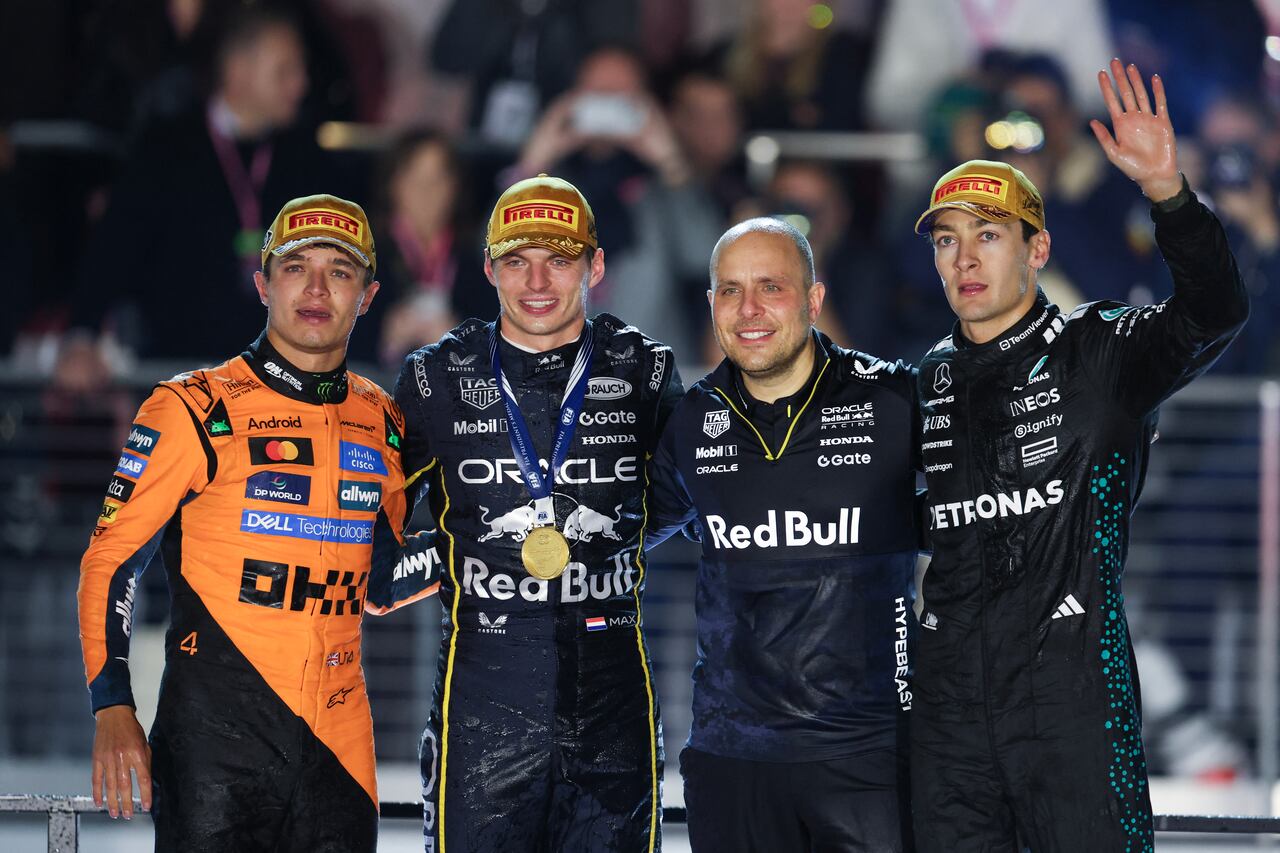 (I/D) El piloto británico Lando Norris (McLaren), que terminó en segundo lugar, el piloto holandés Max Verstappen (Red Bull Racing), el ganador de la carrera, Gianpiero Lambiase (Red Bull Racing) y el piloto británico George Russell (Mercedes), que terminó en tercer lugar, celebran en el podio después del Gran Premio de Fórmula Uno de Las Vegas en el Circuito Las Vegas Strip en Las Vegas, Nevada, el 22 de noviembre de 2025. (Foto de Patrick T. Fallon / AFP)