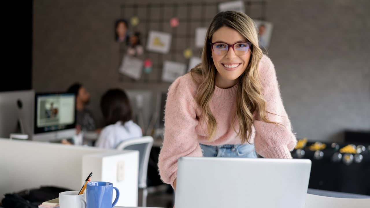 Mujer trabajando en computador portatil. Mujer en oficina.