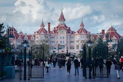 Esta fotografía, tomada el 24 de noviembre de 2025, muestra a los visitantes frente al Hotel Disneyland, que marca la entrada al Parque Disneyland en Disneyland París, en Marne-la-Vallée, al este de París. (Foto de GEOFFROY VAN DER HASSELT / AFP)