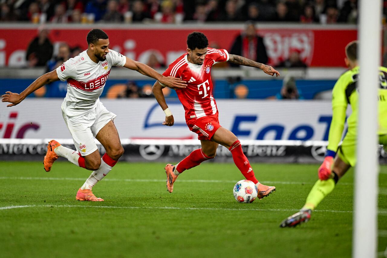 El delantero colombiano #14 del Bayern Múnich, Luis Díaz (centro), y el defensa alemán #04 del VfB Stuttgart, Josha Vagnoman (izquierda), disputan el balón durante el partido de la Bundesliga alemana entre el VfB Stuttgart y el Bayern Múnich en Stuttgart el 6 de diciembre de 2025. (Foto de THOMAS KIENZLE / AFP)