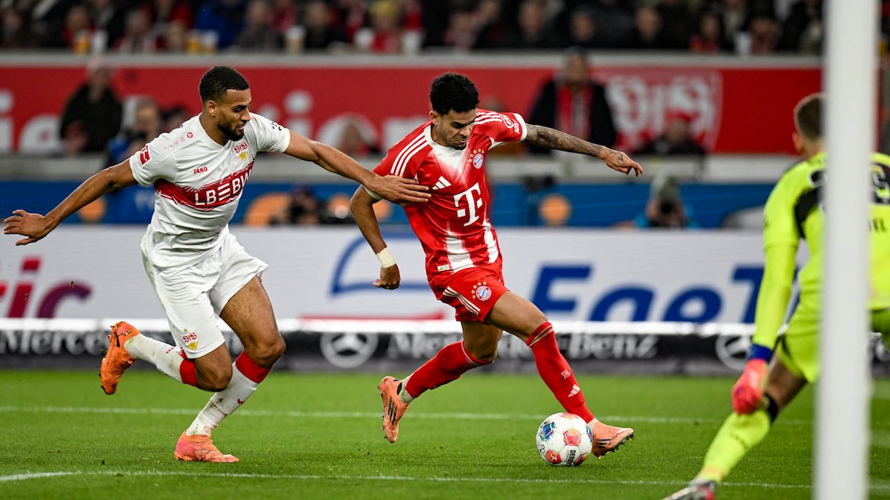 El delantero colombiano #14 del Bayern Múnich, Luis Díaz (centro), y el defensa alemán #04 del VfB Stuttgart, Josha Vagnoman (izquierda), disputan el balón durante el partido de la Bundesliga alemana entre el VfB Stuttgart y el Bayern Múnich en Stuttgart el 6 de diciembre de 2025. (Foto de THOMAS KIENZLE / AFP)