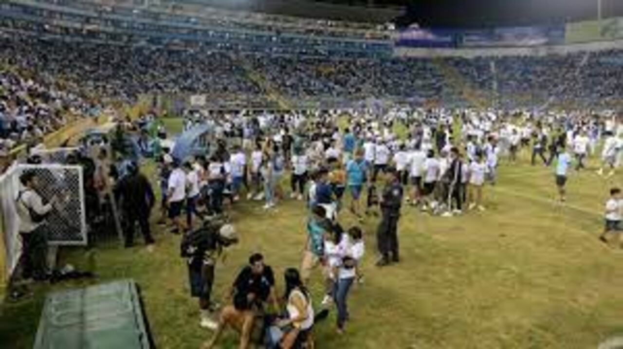 Los simpatizantes son ayudados por otros luego de una estampida durante un partido de fútbol entre Alianza y FAS en el estadio Cuscatlán en San Salvador.