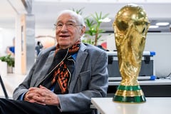 El periodista deportivo y analista de fútbol argentino Enrique Macaya Márquez, de 91 años, posa para una foto con una réplica del trofeo de la Copa Mundial de la FIFA. Desde Suecia 1958, el fútbol ha cambiado en términos tácticos, tecnológicos y económicos. Sin embargo, algo se ha mantenido constante: la presencia del periodista argentino Enrique Macaya Márquez, quien extenderá su récord de cobertura de la Copa Mundial a 18 en Norteamérica 2026. (Foto de Luis ROBAYO / AFP)