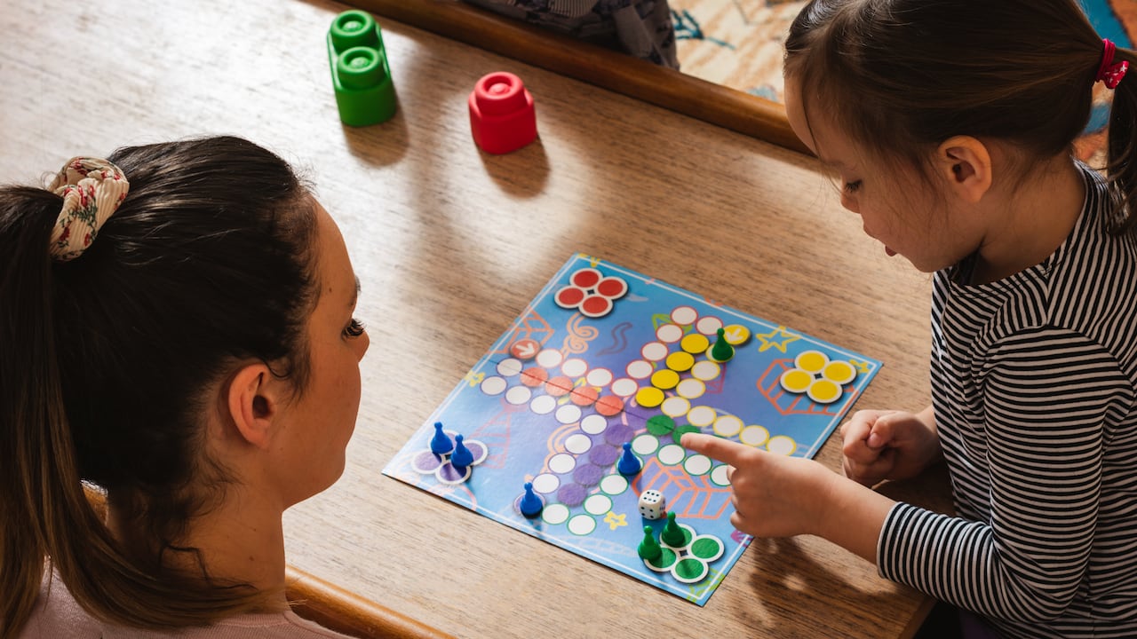 Madre e hija jugando juegos de mesa en casa.