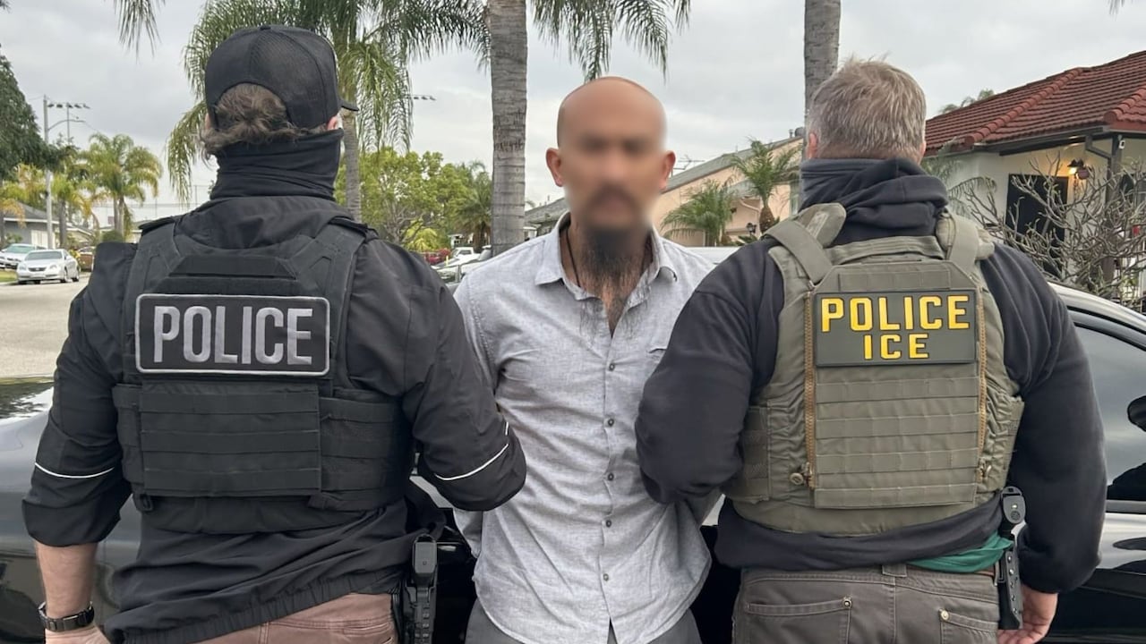 Agentes de ICE junto con un migrante capturado.