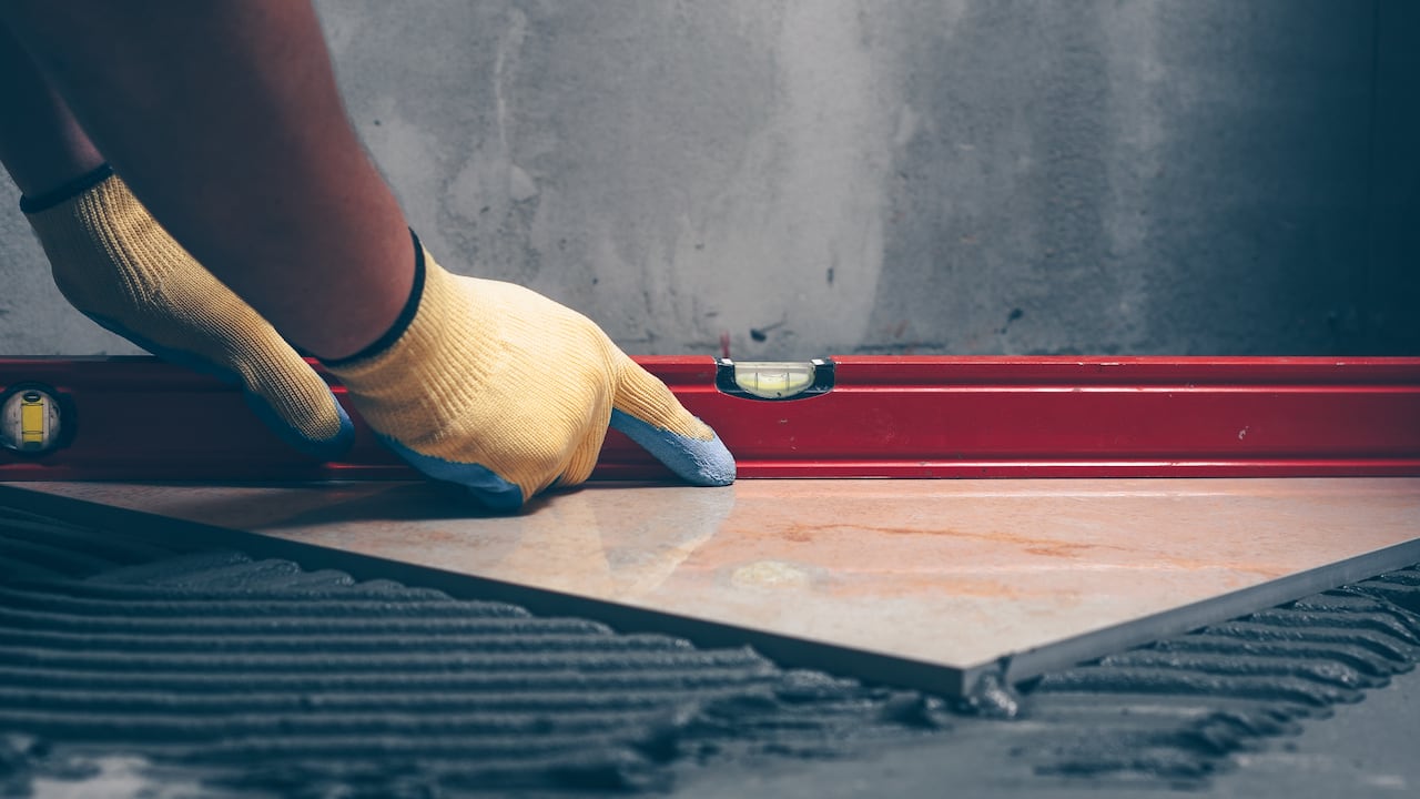 Manos con un nivel de gota en una construcción.