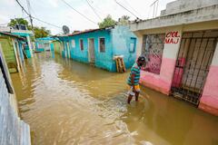 Un hombre camina por una calle inundada tras el paso de la tormenta tropical Melissa, antes de convertirse en huracán, en Santo Domingo, República Dominicana.