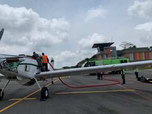 Bomberos aeronáuticos del Aeropuerto Palonegro preparan aeronave de la Policía Nacional para apoyar el control del incendio.