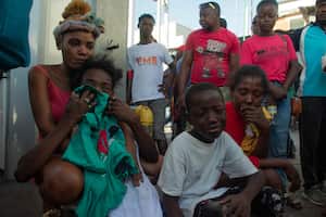 La gente reacciona después de que una docena de personas fueran asesinadas en la calle por pandilleros, en Pétionville, Puerto Príncipe, Haití, el 18 de marzo de 2024.