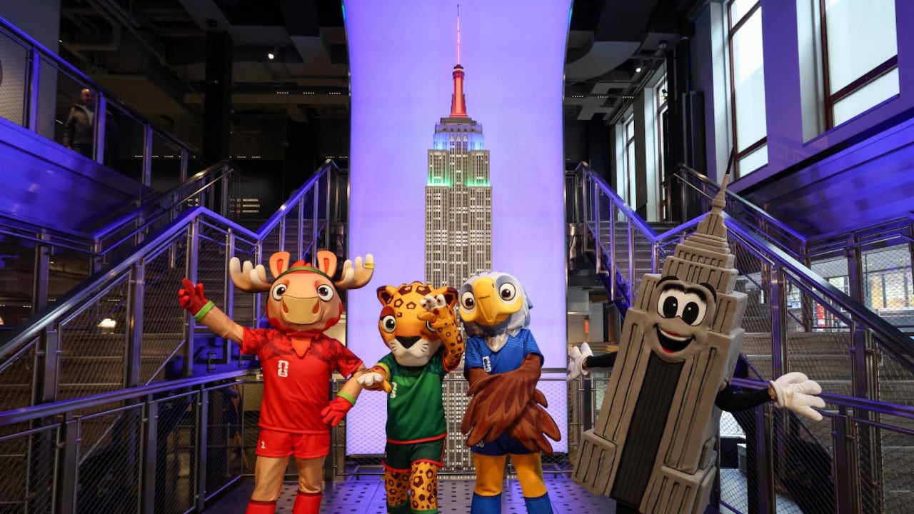 Las mascotas de la Copa Mundial de la FIFA, Maple, Zayu y Clutch, posan con Emma Pire dentro del Empire State Building para celebrar los 100 días del Mundial en Nueva York.