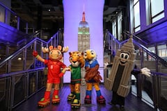 Las mascotas de la Copa Mundial de la FIFA, Maple, Zayu y Clutch, posan con Emma Pire dentro del Empire State Building para celebrar los 100 días del Mundial en Nueva York.