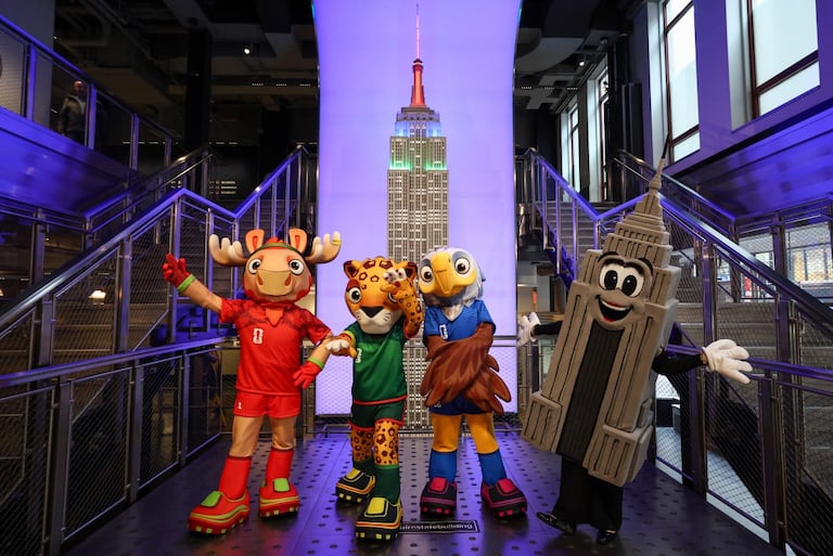 Las mascotas de la Copa Mundial de la FIFA, Maple, Zayu y Clutch, posan con Emma Pire dentro del Empire State Building para celebrar los 100 días del Mundial en Nueva York.