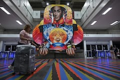A passenger walks along an alley at Simon Bolivar International Airport in Maiquetia, La Guaira State, Venezuela, on November 27, 2025. Venezuela's decision to ban foreign airlines that stopped flying to the Caribbean country over concerns about US military activity was branded "disproportionate" on Thursday as thousands of passengers scrambled to save their travel plans. (Photo by Federico PARRA / AFP)