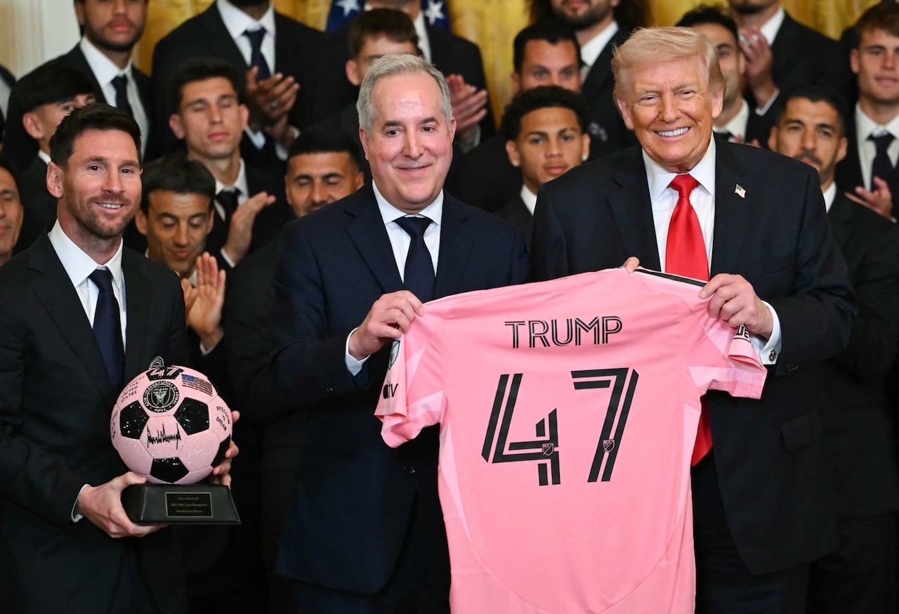 El delantero argentino del Inter Miami, Lionel Messi, el dueño del Inter Miami, Jorge Mas, y el presidente de Estados Unidos, Donald Trump, posan con una camiseta del 47 y un balón autografiado durante un evento en honor al Inter Miami CF, ganador de la Major League Soccer Cup 2025, en el Salón Este de la Casa Blanca en Washington, DC, el 5 de marzo de 2026. (Foto de ANDREW CABALLERO-REYNOLDS / AFP)