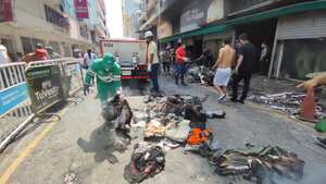 Comerciantes del centro de Cali rescatan lo que pueden del centro comercial el tesoro luego del incendio que consumió a este establecimiento.