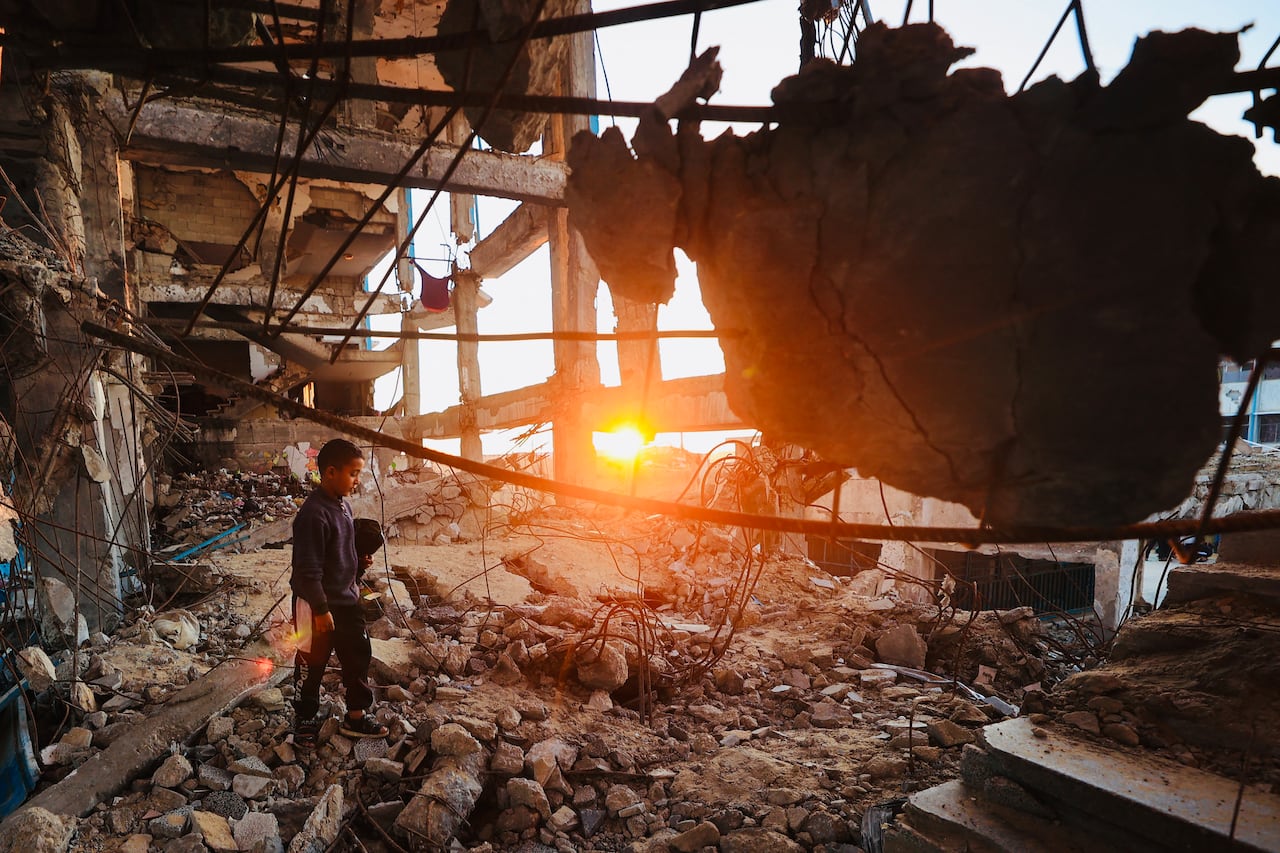 Un niño palestino desplazado camina sobre los escombros antes de tomar el iftar, la comida que rompe el ayuno durante el Ramadán, en medio de la destrucción del campo de refugiados de Bureij, en el centro de la Franja de Gaza, el 25 de febrero de 2026. Foto: Eyad Baba / AFP