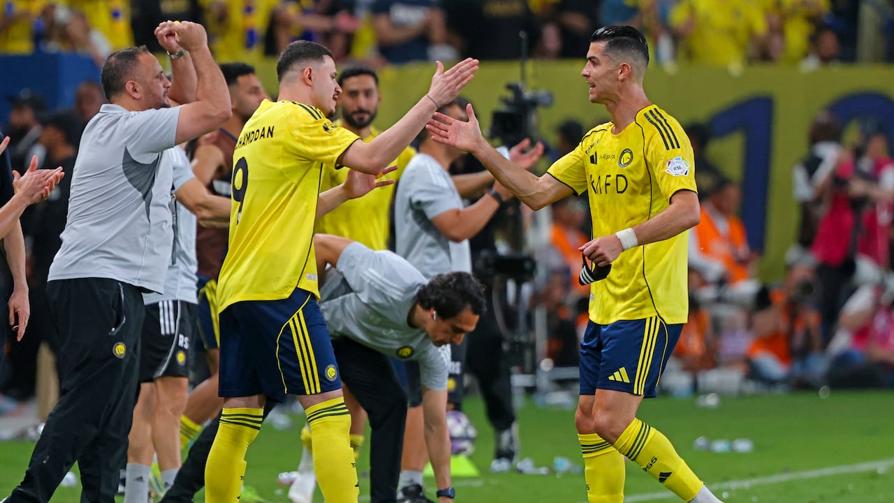 El delantero portugués del Nassr, Cristiano Ronaldo (número 07), estrecha la mano del delantero saudí del Nassr, Abdullah Al-Hamdan (número 09), durante el partido de la Liga Profesional Saudí entre el Al-Nassr y el Al-Hilal en el Estadio King Fahd Sports City de Riad, el 12 de mayo de 2026. (Foto de Fayez NURELDINE / AFP)