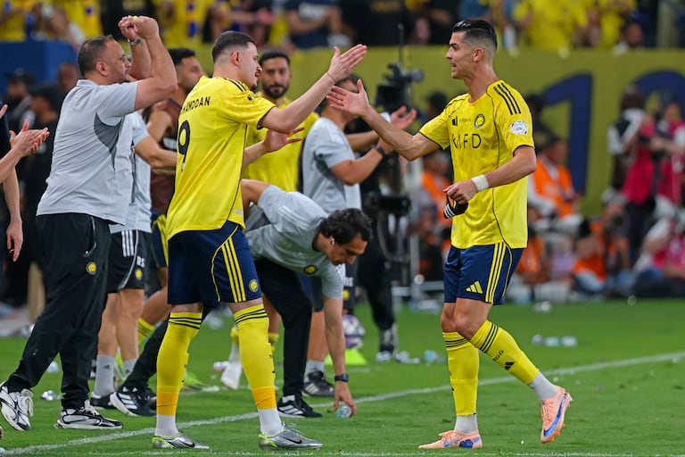 El delantero portugués del Nassr, Cristiano Ronaldo (número 07), estrecha la mano del delantero saudí del Nassr, Abdullah Al-Hamdan (número 09), durante el partido de la Liga Profesional Saudí entre el Al-Nassr y el Al-Hilal en el Estadio King Fahd Sports City de Riad, el 12 de mayo de 2026. (Foto de Fayez NURELDINE / AFP)