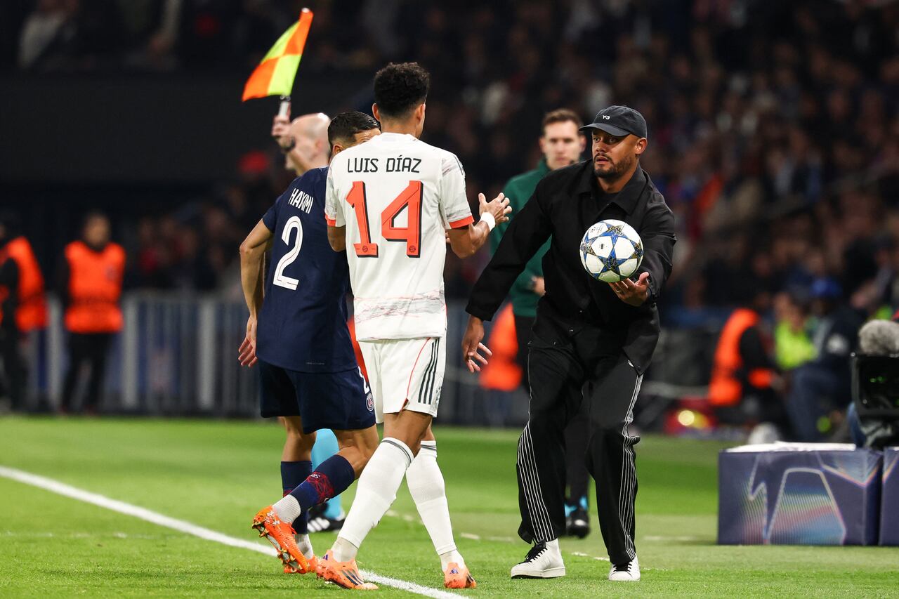 El técnico belga del Bayern de Múnich, Vincent Kompany (D), entrega el balón al delantero colombiano Luis Díaz (n.° 14) durante el partido de la cuarta jornada de la fase de grupos de la UEFA Champions League entre el Paris Saint-Germain (PSG) y el FC Bayern de Múnich en el Parque de los Príncipes de París, el 4 de noviembre de 2025. (Foto de FRANCK FIFE / AFP)