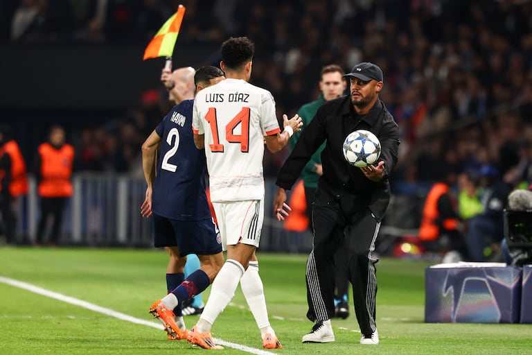 El técnico belga del Bayern de Múnich, Vincent Kompany (D), entrega el balón al delantero colombiano Luis Díaz (n.° 14) durante el partido de la cuarta jornada de la fase de grupos de la UEFA Champions League entre el Paris Saint-Germain (PSG) y el FC Bayern de Múnich en el Parque de los Príncipes de París, el 4 de noviembre de 2025. (Foto de FRANCK FIFE / AFP)