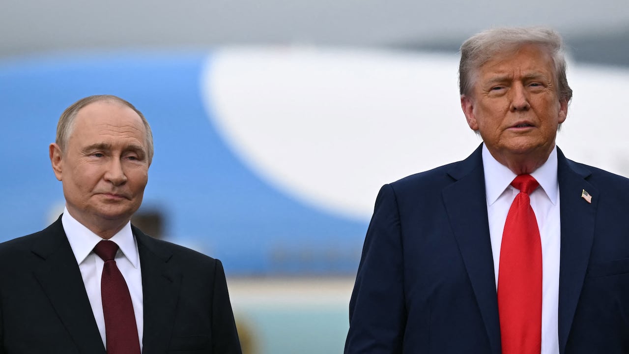 El presidente estadounidense Donald Trump (der.) y el presidente ruso Vladimir Putin posan en un podio en la pista tras su llegada a la Base Conjunta Elmendorf-Richardson en Anchorage, Alaska, el 15 de agosto de 2025.