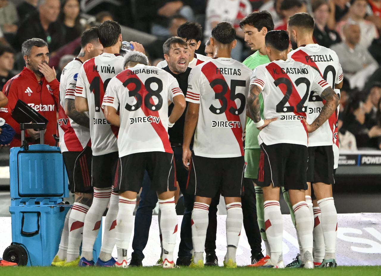 El entrenador de River Plate, Eduardo Coudet, habla con sus jugadores durante el descanso para refrescarse del partido de fútbol de la fase de grupos de la Copa Sudamericana entre River Plate de Argentina y Carabobo de Venezuela en el estadio Mas Monumental de Buenos Aires el 15 de abril de 2026. (Foto de Luis ROBAYO / AFP)