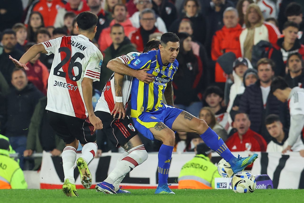 Ángel Di María (derecha), delantero número 11 de Rosario Central, y Matías Viña (centro), defensa uruguayo número 18 de River Plate, luchan por el balón durante la semifinal del torneo Apertura de la Liga Argentina de Fútbol Profesional entre River Plate y Rosario Central en el Estadio Monumental MAS de Buenos Aires, el 16 de mayo de 2026. (Foto de Alejandro PAGNI / AFP)