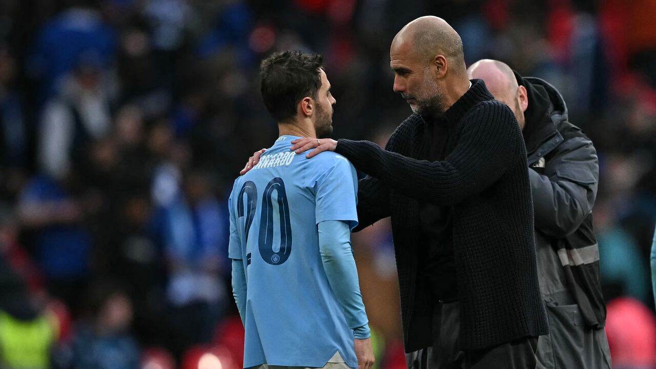 El entrenador español del Manchester City, Pep Guardiola (R), habla con el goleador del centrocampista portugués del Manchester City #20 Bernardo Silva (L) en el campo después del partido de fútbol semifinal de la Copa FA inglesa entre Manchester City y Chelsea en el estadio de Wembley, en el noroeste de Londres. el 20 de abril de 2024. El Manchester City ganó el partido 1-0. Ben Stansall/AFP