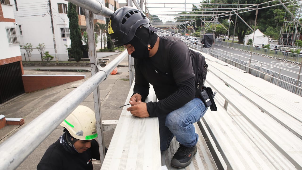 Dos trabajadores montan las graderías que recibirán a los más de 35.000 asistentes diarios a los eventos.