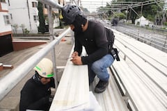 Dos trabajadores montan las graderías que recibirán a los más de 35.000 asistentes diarios a los eventos.