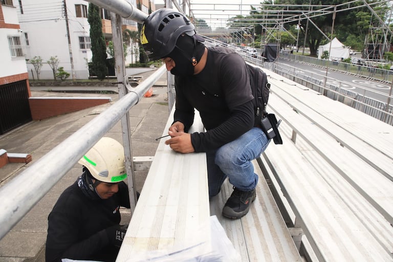Dos trabajadores montan las graderías que recibirán a los más de 35.000 asistentes diarios a los eventos.