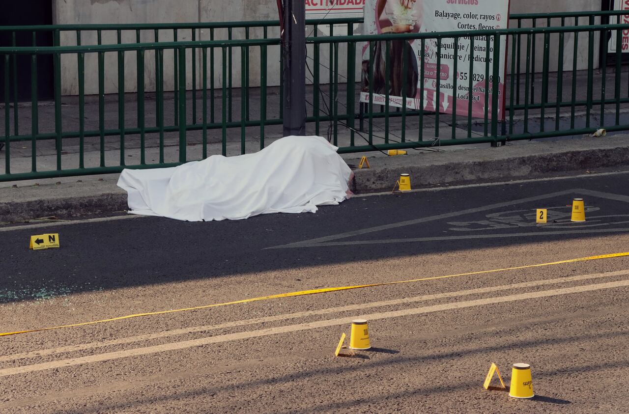 El cuerpo de una de las víctimas quedó en medio de la carretera.