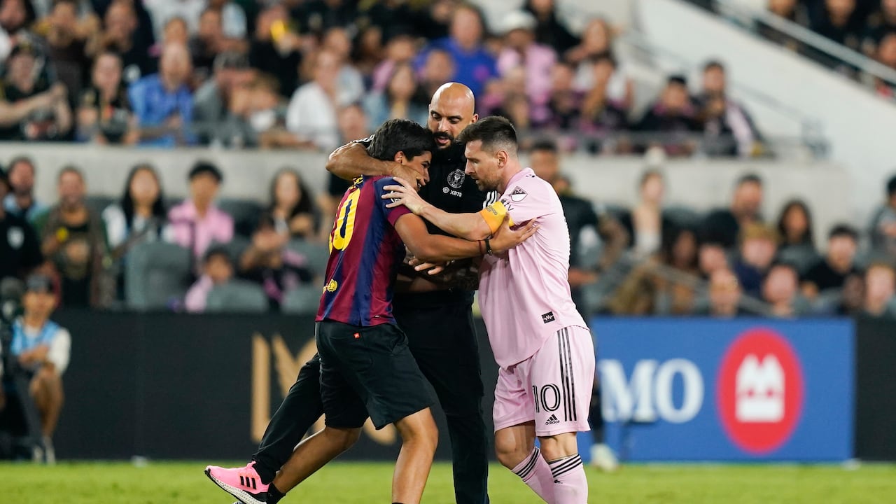 Momento exacto en que Yassine Cheuko defiende a Lionel Messi del abrazo de un fanático que invadió el terreno de juego (AP Photo/Ryan Sun)